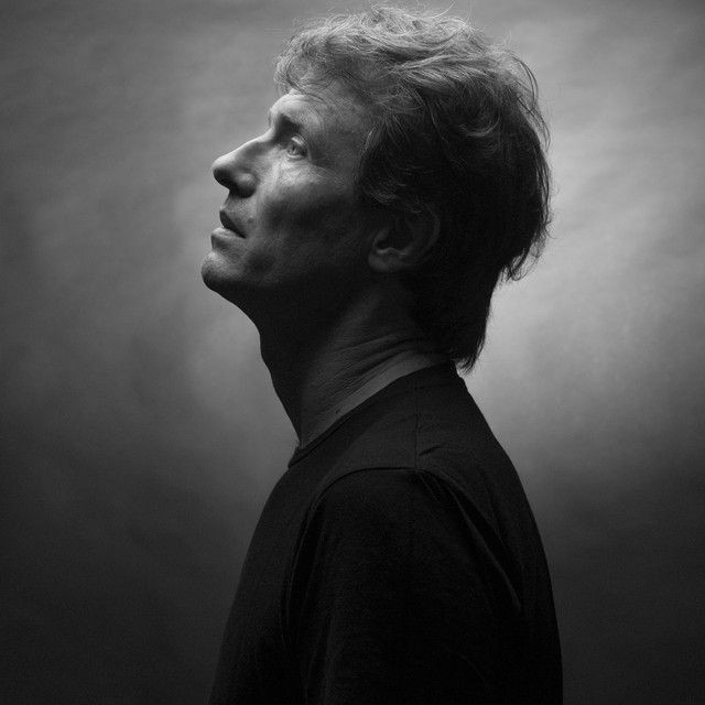 Side profile of a man looking up in dramatic black and white lighting.