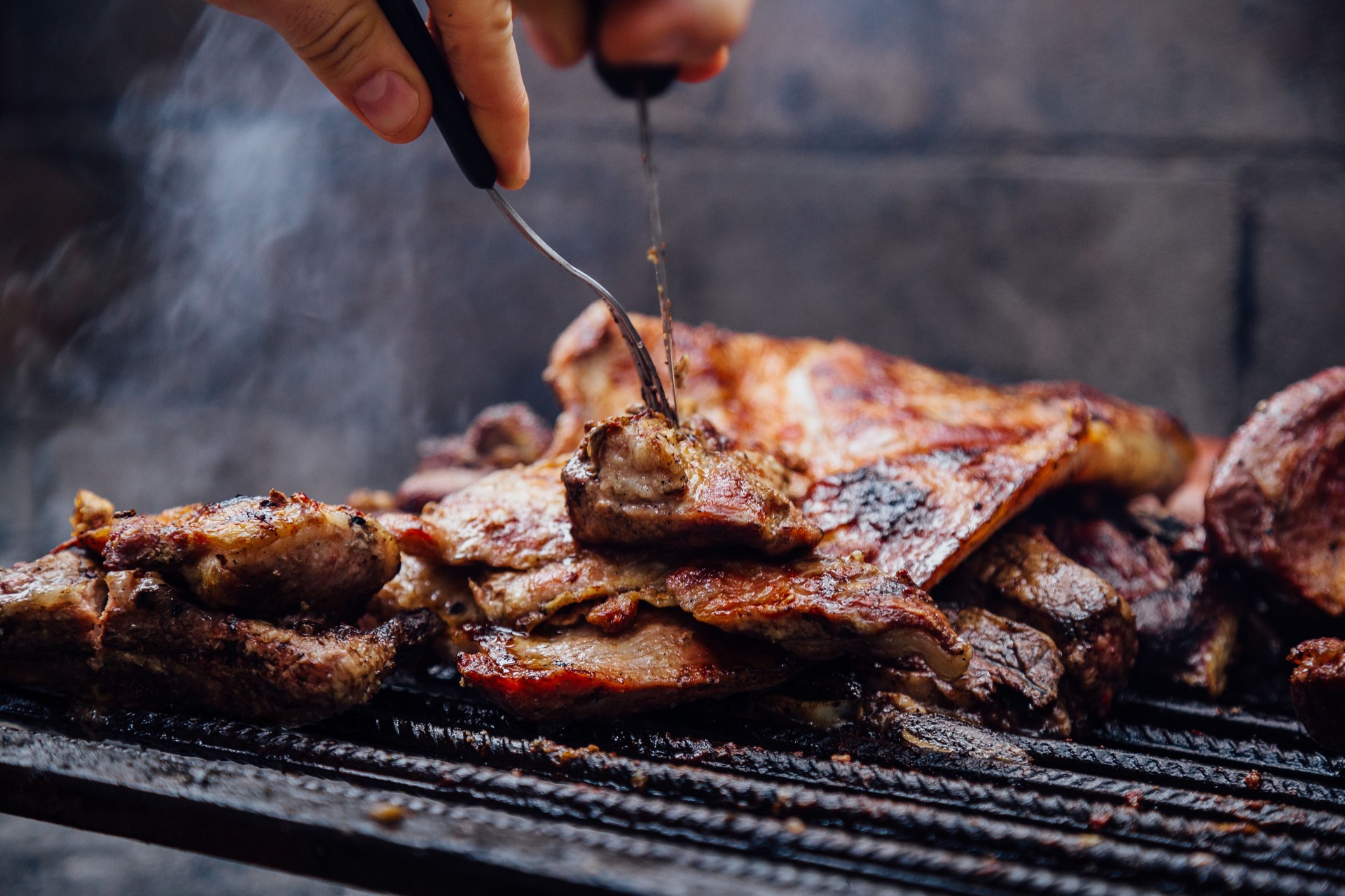 Joven haciendo una barbacoa. Asado tradicional de Argentina.
